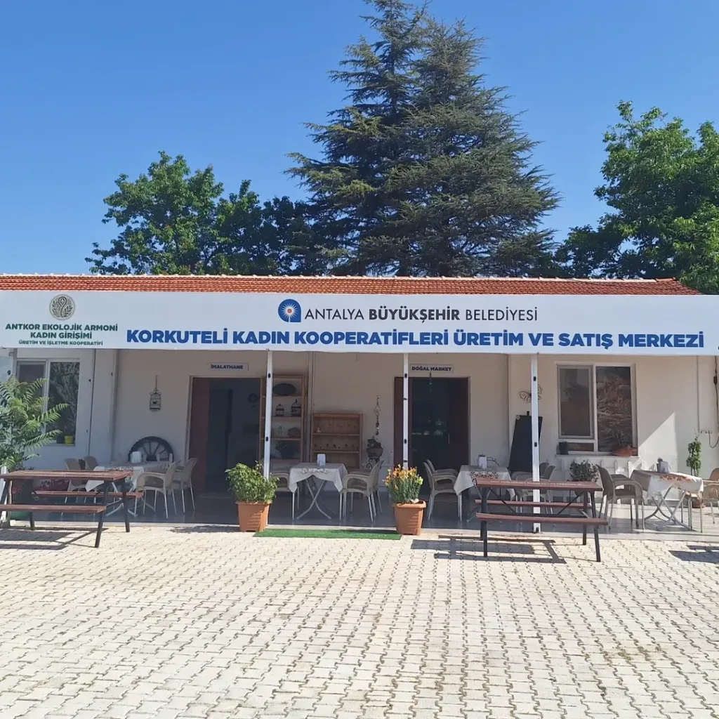 Korkuteli Kadın Kooperatifleri Üretim ve Satış Merkezi binası ve bahçedeki kahvaltı masaları
